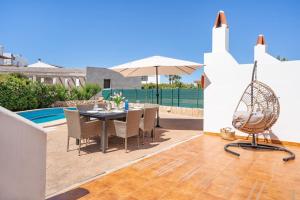 un patio con tavolo, sedie e ombrellone di Villa Ido a Cala'n Bosch