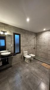 a bathroom with two sinks and a toilet and a sink at Chacras House in Chacras de Coria