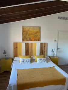 1 dormitorio con 1 cama grande con almohadas amarillas en Vila Alaró TI, en Alaró