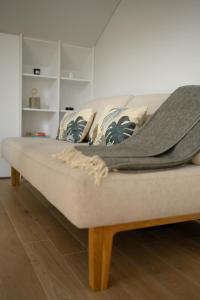 a couch with a blanket on top of it at Pine Attic - new & cozy 3 bedroom apartment,Nida in Nida