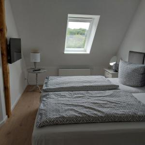 a bedroom with two beds and a window at FeWo Dreiseitenblick Komfort mit 2 Schlafzimmern in Bad Doberan