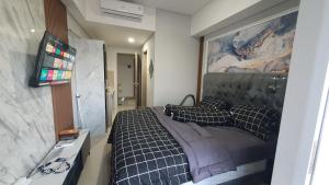 a bedroom with a bed and a flat screen tv at Apartment The Bay AisBeLL in Kuala +35 photos