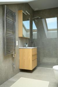 a bathroom with a sink and a shower with a mirror at Pine Attic - new & cozy 3 bedroom apartment,Nida in Nida +37 photos