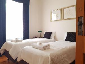 格莱内尔格The Heritage - located in in the center of Glenelg的客房内的两张床和毛巾