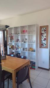 une salle à manger avec une table et une étagère avec de la vaisselle dans l'établissement casa perfeita de sonho e completa, à Armacao dos Buzios