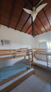 une chambre avec deux lits superposés et un ventilateur de plafond dans l'établissement casa perfeita de sonho e completa, à Armacao dos Buzios