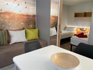 una camera con tavolo, divano e specchio di Sportcamping & Glamping Resort Rio Vantone a Crone
