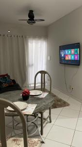 a table and chairs in a living room with a tv at Lugar Perfeito in Rondonópolis
