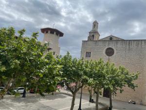 a building with two towers and trees in front of it at Vila Alaró TI in Alaró