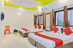 a hotel room with two beds and a window at OYO Hotel Shirdi Sai Inn in Shirdi