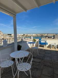 a patio with tables and chairs on a balcony at San Pietro Otranto in Otranto