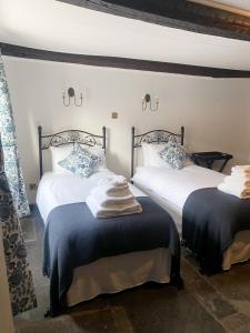 um quarto com 2 camas com almofadas azuis e brancas em The New Inn em Yeovil
