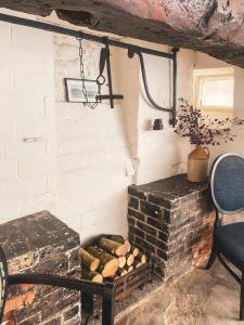 um quarto com uma lareira de tijolos ao lado de uma cadeira em The New Inn em Yeovil