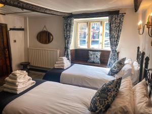 1 dormitorio con 2 camas y ventana en The New Inn en Yeovil