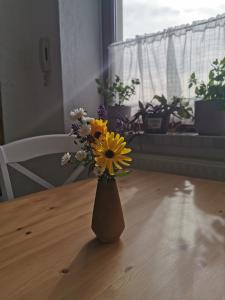 un jarrón lleno de flores sentado en una mesa en Zur alten Schnitzerei en Grünhainichen