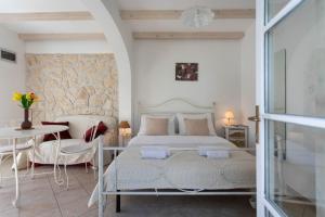 a white bedroom with a bed and a table at Poolside Stone Residences - Marina Bok in Novalja +255 photos