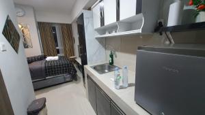 a small kitchen with a sink and a bedroom at Apartment The Bay AisBeLL in Kuala