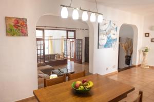 ein Esszimmer mit einem Tisch und einer Obstschale darauf in der Unterkunft Villa Blanca Nudist Exclusive in Charco del Palo