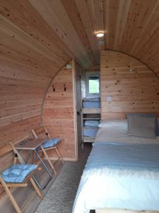 ベトウス・ア・コーエドにあるSiabod Hutsのログキャビン内のベッドルーム(ベッド1台、テーブル付)