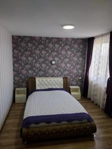 um quarto com uma cama com um edredão roxo e branco em Randevu em Caracal