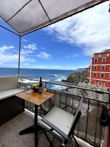 a balcony with a table and chairs and the ocean at Il mare in casa in Riomaggiore +58 photos