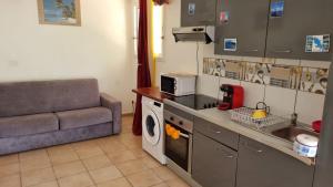 a kitchen with a couch and a sink and a washing machine at Hibiscus et Miro in Ducos