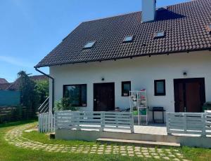 a white house with a fence next to it at Jagodzianka in Miłki