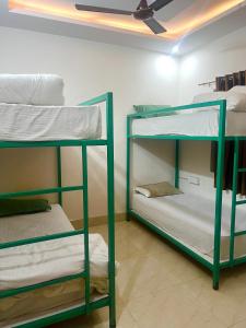 two bunk beds in a room with a ceiling at Shanti Hostel Rishikesh in Rishīkesh