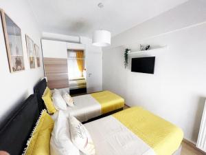 a small bedroom with two beds and a tv at GetHome City Charm in Thessaloniki +11 photos