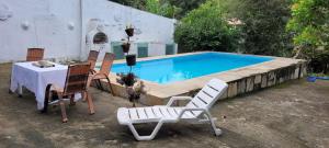 a table and chairs sitting next to a swimming pool at Pendotiba Hostel in São Gonçalo
