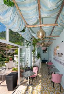 Pokój ze stołami i krzesłami oraz sufitem w obiekcie Hostel Brikette w mieście Positano