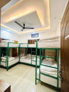 4 łóżka piętrowe w pokoju z sufitem w obiekcie Shanti Hostel Rishikesh w mieście Rishikesh