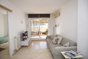 sala de estar con sofá y TV en Apartamento con dos grandes terrazas en Girona, en Girona