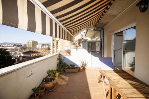 balcón al aire libre con mesa y macetas en Apartamento con dos grandes terrazas en Girona, en Girona