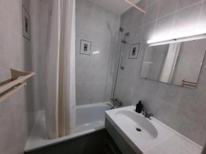 biała łazienka z umywalką i wanną w obiekcie Appartement Lumineux à Seignosse, Proche Plage, Commerces et Activités, Parking, Wifi et Balcon - FR-1-239-813 w mieście Seignosse +9 zdjęć