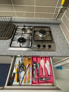 a stove top in a kitchen with some utensils at DHeights Monterrace Clark Studio with Kitchen Overlooking Balcony in Pampang +5 photos