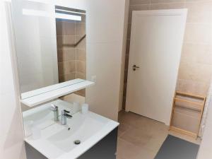 a white bathroom with a sink and a mirror at Appartement moderne 3* avec balcon, proche du lac et plage, parking privatif, Wi-Fi inclus - FR-1-239-862 in Soorts-Hossegor +12 photos