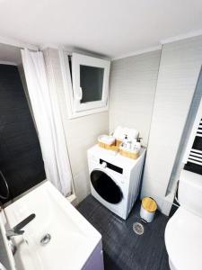 a small bathroom with a sink and a microwave at GetHome City Charm in Thessaloniki