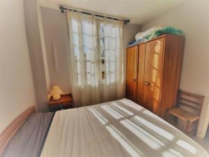 sypialnia z łóżkiem, krzesłem i oknem w obiekcie Appartement cosy 4 pers, proche plage et commerces, Capbreton - FR-1-239-887 w mieście Capbreton