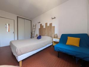 a bedroom with a bed and a blue chair at Appartement T2 à Collioure avec Terrasse et Parking Privé, à 300m de la Plage - FR-1-309-385 in Collioure
