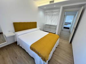a bedroom with a large bed with a yellow blanket at Marusía in Muxia