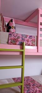 a bunk bed with a green ladder and a pink bunk bed at SULTANA Beach Riad in Saidia 