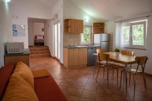 a kitchen and living room with a couch and a table at Apartments Andreja in Pag