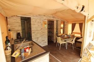 una cucina e una zona pranzo di una tenda con tavolo di Sportcamping & Glamping Resort Rio Vantone a Crone