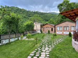 a garden with a stone path in front of a house at Balkonchik GuestHouse in Dilijan