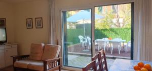 een kamer met een glazen schuifdeur en een tafel met een paraplu bij Casa Mas Pinell 93 in Torroella de Montgrí