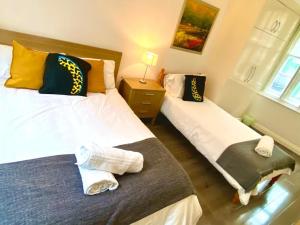 ein Schlafzimmer mit 2 Betten und einem Tisch mit einer Lampe in der Unterkunft Shoreditch & Liverpool Street Room B in London