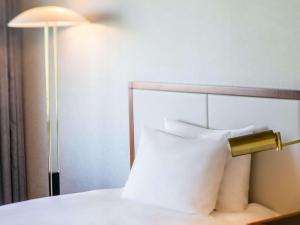 a close up of a bed with a lamp at Mercure Kochi Tosa Resort & Spa in Geisei