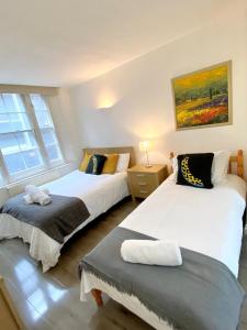 2 Betten in einem Zimmer mit 2 Fenstern in der Unterkunft Shoreditch & Liverpool Street Room B in London
