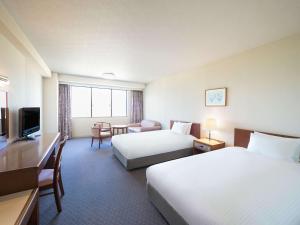 Mercure Wakayama Kushimoto Resort & Spa في كوشيموتو: غرفه فندقيه سريرين وتلفزيون